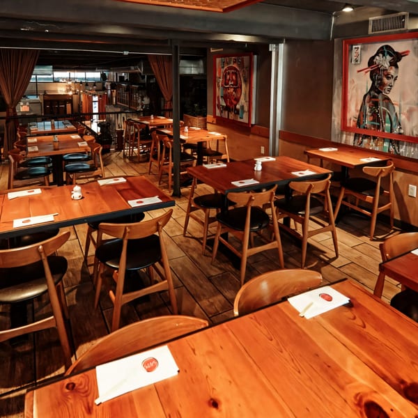 Sapps Nyc Japanese restaurant interior with wooden tables, chairs, and Japanese-themed artwork on the walls.