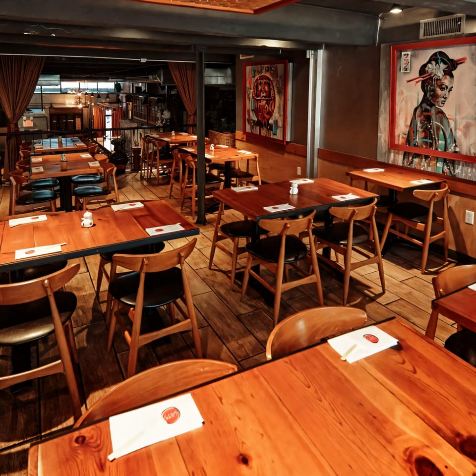 Sapps Nyc Japanese restaurant interior with wooden tables, chairs, and Japanese-themed artwork on the walls.