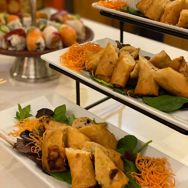 Crispy Japanese spring rolls and fresh sushi rolls displayed on a tiered serving stand.